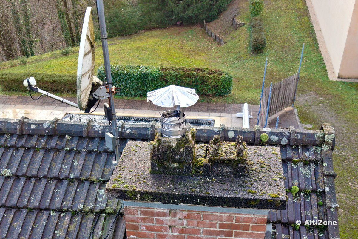 Vue rapprochée d’une cheminée, de tuiles et d’une antenne